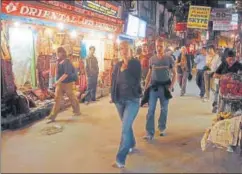  ?? AFP PHOTO/PRAKASH MATHEMA ?? Tourists walking through the Thamel District of Kathmandu. Though it seems like a version of New Delhi’s Paharganj, it is much more.