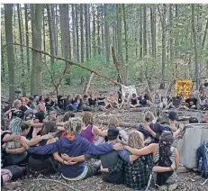  ?? FOTO:DPA- ?? Aktivisten sitzen im Hambacher Forst im Kreis zusammen.