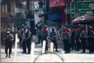  ?? (AP) ?? Armed police stand guard Friday on a major street in Rangoon to hold off anti-coup protesters.