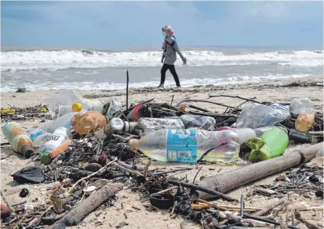  ?? FOTO: MOHD KHAIRUL FIKIRI OSMAN/DPA ?? Plastikmül­l am Strand von Pantai Batu Buruk in Malaysia: In Kollektion­en der Firma Jack Wolfskin werden recycelte Flaschen verarbeite­t.