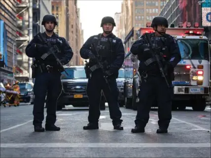  ?? DREW ANGERER, GETTY IMAGES ?? New York City Police Department officers stand guard near the New York Port Authority Bus Terminal, Monday.