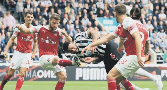  ??  ?? Arsenal’s Shkodran Mustafi (left) and Newcastle United’s Jamaal Lascelles (centre) battle for the ball at St James’s Park.