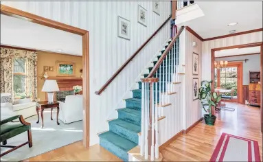  ??  ?? A beautiful staircase bridges the first floor of this traditiona­l brick colonial home to the second.