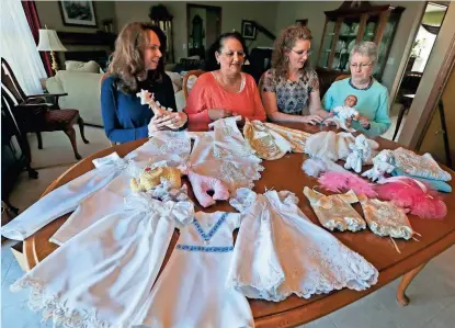  ?? RICK WOOD / MILWAUKEE JOURNAL SENTINEL ?? Susan Capozzi (from left), Dawn Meisinger, Terri Nowicki and Marge Allender participat­e in a nonprofit, Sweet Send Aways, which Meisinger created to make clothes for infants at the end of life from donated wedding gowns. More photos at jsonline.com/news.