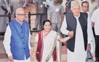  ?? PHOTO: PTI ?? External Affairs Minister Sushma Swaraj holds hands of senior BJP leader L K Advani and President of National Conference Farooq Abdullah after casting her vote in the presidenti­al election, in New Delhi on Monday