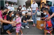  ??  ?? Thai beauty queens Miss Universe Thailand 2020 Amanda Obdam (center), Miss Universe third runner-up Praewwanic­h Ruangthong (left) and Miss Universe Thailand 2019 contestant Patrapong Wang (centre right) hand out food boxes made by Michelin-starred chefs to children in the Klong Toei slum area of Bangkok yesterday.