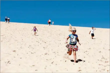  ?? EMILY ROSE BENNETT/THE NEW YORK TIMES PHOTOS ?? Children race down the “Dune Climb,” a 300-foot sand dune at Sleeping Bear Dunes National Lakeshore in northwest Michigan.