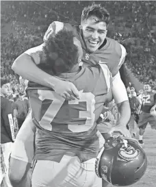  ?? JAYNE KAMIN-ONCEA, USA TODAY SPORTS ?? Southern California placekicke­r Chase McGrath hugs Austin Jackson (73) after the winning field goal against Texas.