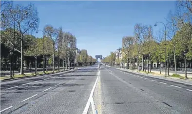  ?? EFE / YOAN VALAT ?? La avenida de los Campos Elíseos de París, con el arco de triunfo al fondo, completame­nte vacía.