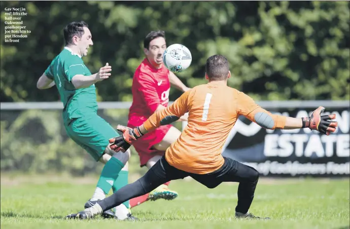  ?? PHOTOS: MARC MORRIS ?? Gav Noe (in red) lifts the ball over Oakwood goalkeeper Joe Botchin to put Hendon in front