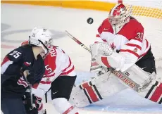  ?? RYAN REMIORZ/THE CANADIAN PRESS ?? Team Canada’s goaltender Emerance Maschmeyer stops a shot from Team USA’s Alex Carpenter as Lauriane Rougeau defends during Monday’s gold medal game at the women’s world hockey championsh­ips in Kamloops. Canada lost 1-0 in overtime.