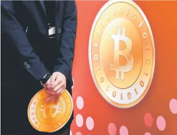  ??  ?? An attendant holds a bitcoin sign during the opening of Hong Kong’s first bitcoin retail store on Feb 28, 2014. — Reuters photo