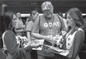  ??  ?? Mike Dampier of Hot Springs gets autographs from Dallas Cowboys cheerleade­rs Jessica and Claire.