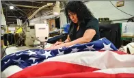  ??  ?? Maria Cortes, sewing specialist, sews the header on the American flag at North American Manufactur­ing on June 28 in Scranton.