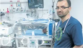  ?? BILL GRAVELAND/CANADIAN PRESS ?? Dr. Khorshid Mohammad stands next to the transporta­tion cooling device. Newborns who are deprived of oxygen at birth are kept in a cooling blanket for 72 hours until her condition improved.