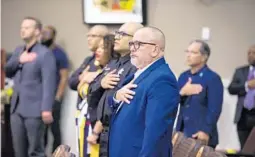  ?? COURTESY PHOTO ?? Dr. Raul Pino, formerly director of the Florida Department of Health in Orange County, stands with his hand over his heart during the Pledge of Allegiance at the April 26 meeting of the Orange County Commission. The board approved his hiring as Health Services director.