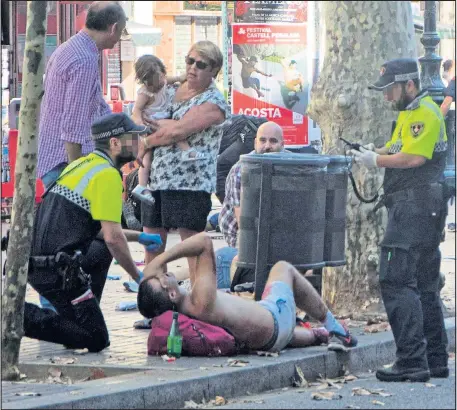  ?? Pictures: DAVID ARMENGOU/EPA PAU BARRENA/AFP ?? Members of the emergency services rushed to the aid of the injured in the wake of the van terror attack yesterday