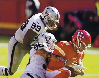  ?? CHARLIE RIEDEL — THE ASSOCIATED PRESS ?? The Chiefs’ Patrick Mahomes is sacked by the Raiders’ Maxx Crosby (98) and Arden Key (99) during the second half on Sunday in Kansas City.