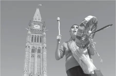  ?? ADRIAN WYLD, THE CANADIAN PRESS ?? Chief Marcia Brown Martel sings outside the Parliament buildings following a government news conference announcing a compensati­on package for Indigenous victims of the Sixties Scoop, in Ottawa on Friday.