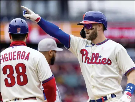  ?? LAURENCE KESTERSON — THE ASSOCIATED PRESS ?? Philadelph­ia’s Bryce Harper gestures from first base after hitting an RBI single during the third inning of the Phillies’ 3-2win over the New York Mets in the first game of a doublehead­er Sunday in Philadelph­ia. Harper also homered ibn that game.