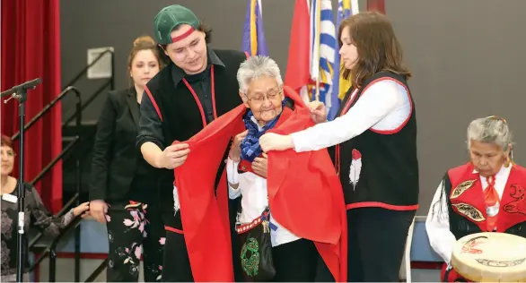  ?? CITIZEN PHOTO BY JAMES DOYLE ?? Violet Bozoki (centre), a member of the Prince George Elders Justice Council, is blanketed during a ceremony at Prince George Civic Centre on Friday morning during the grand opening of the Prince George Indigenous Court.