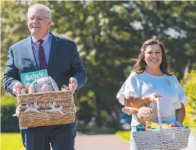  ?? ?? Prime Minister Scott Morrison and his wife Jenny, above, visiting Westmead Children’s Hospital, Sydney; and, right, Morrison with Jenny and daughters Abbey, 14, and Lily, 12, and their dog Buddy at Kirribilli House, Sydney.