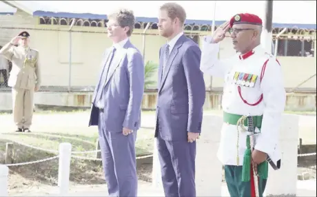  ??  ?? Prince Harry (centre), British High Commission­er Gregory Quinn (left) and a senior member of the Guyana Defence Force receiving the salute during a visit to Commonweal­th War Graves