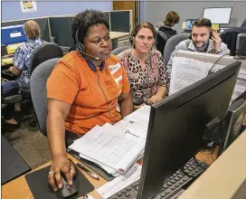 ?? RALPH BARRERA / AMERICAN-STATESMAN ?? Tereassa Mack (left), training to become an intake specialist, takes phone calls as trainers Emily Hughes (center) and Harold Crowson III provide assistance at the Statewide Intake Call Center. Each call on average lasts about 15 minutes, and each call...