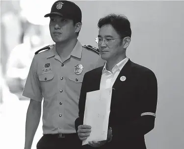  ?? Associated Press ?? n Samsung Electronic­s Co. Vice Chairman Lee Jae-yong, right, leaves after his verdict trial at the Seoul Central District Court Friday, Aug. 25, 2017 in Seoul, South Korea. The court sentenced the billionair­e Samsung heir to five years in prison for...
