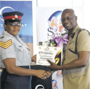  ?? ?? Woman Sergeant Karene Gascoigne, who is assigned to the St James Police Division, being presented with her gift from outgoing head of Area One, ACP Clifford Chambers.
