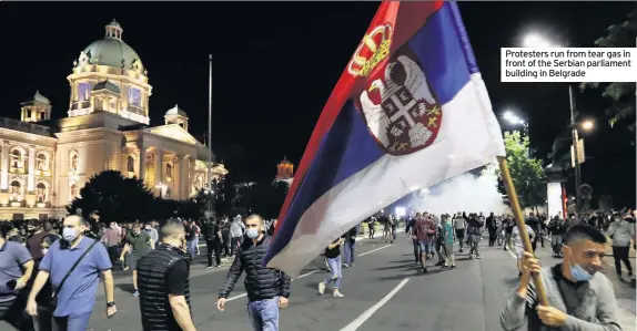  ??  ?? Protesters run from tear gas in front of the Serbian parliament building in Belgrade