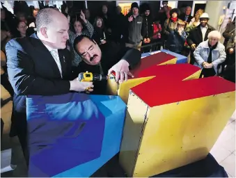  ?? DAN JANISSE ?? An additional 25 items were put into the City of Windsor time capsule for its 125th birthday during a ceremony on Sunday. Mayor Drew Dilkens, left, seals the capsule with help from city employee Sebastian Pirrone.