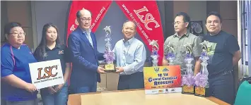  ??  ?? Sim (third left) presents the sponsored items to Nansian as Redeems committee members and LSC staff look on.