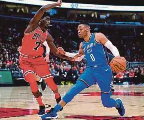  ?? REUTERS PIC ?? Oklahoma City Thunder guard
Russell Westbrook (right) dribbles the ball against Chicago Bulls guard Justin Holiday during their NBA game on Saturday.