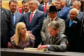  ?? JEFF AMY — THE ASSOCIATED PRESS ?? Georgia Gov. Brian Kemp signs a budget amendment at the Georgia Capitol, Thursday, Feb. 29, 2024 in Atlanta. The measure will boost state government spending by nearly $5.5 billion through June 30.