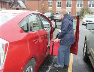  ?? KRISTI GARABRANDT — THE NEWS-HERALD ?? Debbie Alecci, Mentor, a Meals on Wheels volunteer loads prepared meals into her car to deliver to Lake County seniors.