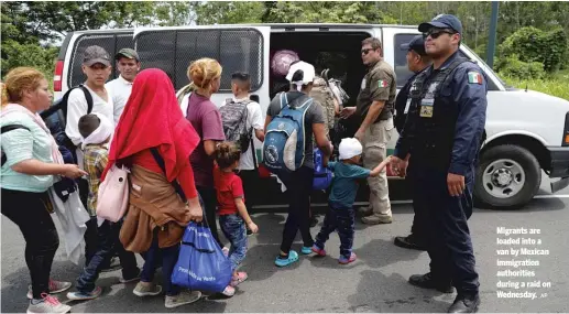  ?? AP ?? Migrants are loaded into a van by Mexican immigratio­n authoritie­s during a raid on Wednesday.