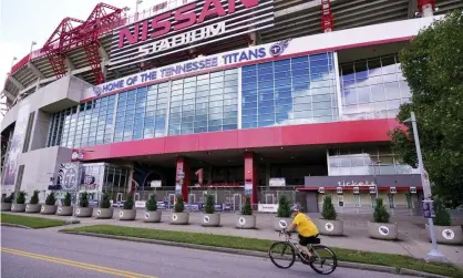  ?? Photograph: Mark Humphrey/AP ?? A cyclist passes by Nissan Stadium, home of the NFL’s Tennessee Titans. With the two new Covid-19 cases, the Titans’ total is now 11: five players and six other organizati­on members.