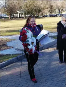  ??  ?? DAR Regent Heather Mabee places a wreath during ceremonies honoring those who perished during the Japanese attack on Pearl Harbor.