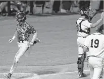  ?? ?? Reagan’s Britton Moore scores in the seventh inning Friday against the defending state champions.