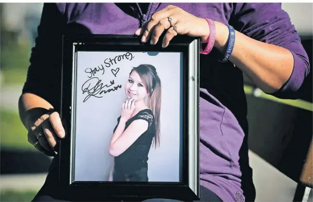  ?? FOTO: DARRYL DYCK/DPA ?? Carol Todd zeigt ein Foto ihrer Tochter Amanda, die sich im Alter von 15 Jahren das Leben nahm.