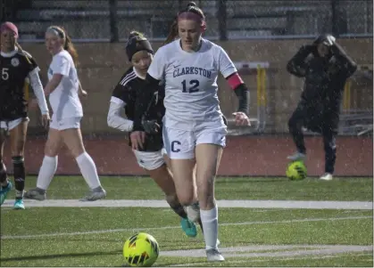  ?? BRYAN EVERSON PHOTOS — MEDIANEWS GROUP ?? Clarkston senior McKinlee Brumm dribbles while being chased by Rochester Adams junior midfielder Sadie Rogers in Tuesday’s match.