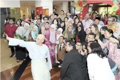  ?? - Bernama photo ?? Communicat­ions and Multimedia Minister Gobind Singh Deo (center) having a photo session with employees of Malaysia Digital Economy Corporatio­n.