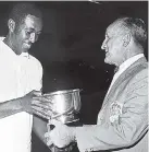  ??  ?? 1971: Keith Palmer (left), who retained the All-Jamaica Badminton Championsh­ips title, receiving the title prize from Jamaica Badminton Associatio­n President Balfe Bradley.