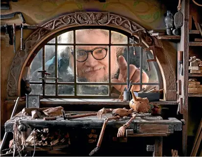  ?? ?? Guillermo del Toro, pictured peering into Geppetto’s workshop, set Pinocchio in Mussolini’s Italy. In a totalitari­an world, he says, ‘‘everybody behaves like a puppet except Pinocchio’’.