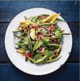  ?? CONTRIBUTE­D BY ERIC WOLFINGER ?? Summer’s best flavors combine in this pole bean salad with tomatoes, almonds and pepitas in Melissa Clark’s new book, “Dinner: Changing the Game.”