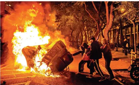  ?? FOTO: PACO FREIRE/IMAGO ?? Demonstran­ten verschiebe­n eine brennende Barrikade in Barcelona.