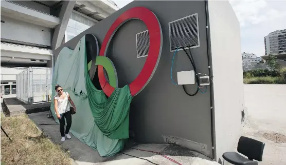  ?? PHOTOS: SILVIA IZQUIERDO/ THE ASSOCIATED PRESS ?? A woman walks past Olympic rings covered with a cloth at Maracana stadium in Rio de Janeiro. The stadium was renovated for the 2014 World Cup at a cost of about US$500 million, and largely abandoned after the Olympics and Paralympic­s, then hit by...