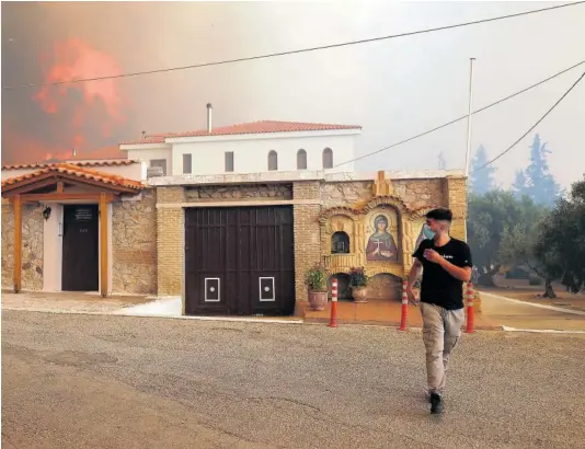  ?? COSTAS BALTAS ?? Un hombre se cubría la boca con una mascarilla durante un incendio cerca de Atenas el pasado agosto.