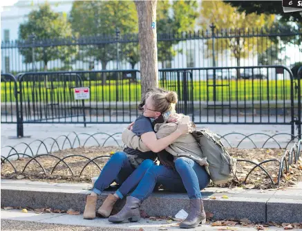  ??  ?? One woman comforts another, who said she was upset by the result of the U.S. presidenti­al election and needed a hug, in front of the White House in Washington, D.C.